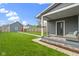 This backyard features a gray home, green grass, and a porch at 953 Harrison St, Indianapolis, IN 46202