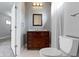 Charming bathroom with a dark wood vanity, framed mirror, tile flooring, and toilet at 953 Harrison St, Indianapolis, IN 46202