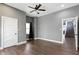 An open bedroom with hardwood floors, gray walls, a ceiling fan, and white trim at 953 Harrison St, Indianapolis, IN 46202