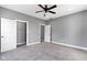Spacious bedroom featuring a ceiling fan, neutral gray walls, carpet flooring, and a walk-in closet at 953 Harrison St, Indianapolis, IN 46202