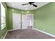 Bedroom with green walls, natural light from a window, and a doorway to an adjacent hall at 953 Harrison St, Indianapolis, IN 46202
