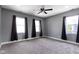 A bright bedroom with gray walls, neutral carpet, dark curtains, and a ceiling fan at 953 Harrison St, Indianapolis, IN 46202