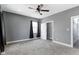 A gray bedroom with neutral carpet, a ceiling fan, and an adjoining closet at 953 Harrison St, Indianapolis, IN 46202