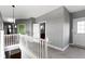 An upstairs hallway featuring neutral walls and carpet, with two doors and white railings at 953 Harrison St, Indianapolis, IN 46202