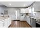Bright kitchen with stainless steel appliances, granite counters, white cabinets and wainscotting at 953 Harrison St, Indianapolis, IN 46202