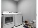 A well-equipped laundry room showcases modern washer and dryer units and a shoe rack at 953 Harrison St, Indianapolis, IN 46202
