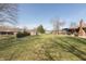 Large backyard featuring mature trees, a lawn, a shed, and a covered patio attached to a brick home at 1002 Corey Ln, Plainfield, IN 46168