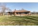 The home features a large backyard with a brick exterior, a covered patio, and mature trees at 1002 Corey Ln, Plainfield, IN 46168