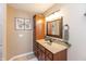 Cozy bathroom with storage cabinet, vanity with framed mirror and a butterfly art piece on the wall at 1002 Corey Ln, Plainfield, IN 46168