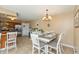 Well-lit dining room area with a white table and chairs with tiled floors and a chandelier at 1002 Corey Ln, Plainfield, IN 46168