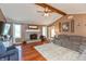 Cozy living room with a vaulted ceiling, a brick fireplace, and comfortable seating with hardwood floors at 1002 Corey Ln, Plainfield, IN 46168