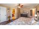 A spacious primary bedroom boasts wood floors, a ceiling fan, and an en-suite bathroom at 1002 Corey Ln, Plainfield, IN 46168
