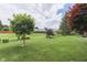 Manicured backyard with mature trees, landscaping, and a bench at 1021 Hudson Bay Dr, Greenwood, IN 46142
