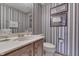 A traditional bathroom showcases striped wallpaper, framed pictures, and a white countertop sink at 1021 Hudson Bay Dr, Greenwood, IN 46142