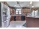 Bright kitchen with wood cabinetry, tiled backsplash, stainless steel refrigerator, and center island with cooktop at 1021 Hudson Bay Dr, Greenwood, IN 46142