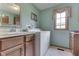 Functional laundry room with a washer, dryer, sink, ample countertop space, and a bright window, offering convenience and efficiency at 1021 Hudson Bay Dr, Greenwood, IN 46142