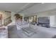Open-concept living room with neutral carpet, access to the staircase, and large TV at 1021 Hudson Bay Dr, Greenwood, IN 46142