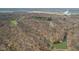 Aerial view showcases the property's serene pond, surrounded by lush, dense woodland and a neighboring industry at 1037 E Woodall Ct, Martinsville, IN 46151