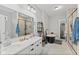Well-lit bathroom featuring double sinks, a modern vanity, and a luxurious black soaking tub with stylish tile floors at 1037 E Woodall Ct, Martinsville, IN 46151