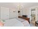 Bright bedroom with a chandelier, playful artwork, and a view into an adjacent bathroom at 1037 E Woodall Ct, Martinsville, IN 46151