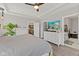 Light-filled bedroom boasts a ceiling fan, large dresser, and doorway to an adjoining bathroom with a soaking tub at 1037 E Woodall Ct, Martinsville, IN 46151