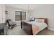 Relaxing bedroom features a cozy chair, chandelier, and a large window offering peaceful outdoor views at 1037 E Woodall Ct, Martinsville, IN 46151