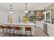 Well-lit kitchen featuring a large island, counter seating, modern backsplash and stainless steel appliances at 1037 E Woodall Ct, Martinsville, IN 46151