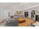 Open-concept living room featuring a large sectional sofa, modern lighting, and a view into the kitchen at 1037 E Woodall Ct, Martinsville, IN 46151