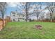 Expansive backyard featuring a fire pit, trampoline, and wood fence at 11117 Harriston Dr, Fishers, IN 46037