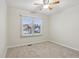 Bright bedroom with neutral carpet, ceiling fan, and a window offering a neighborhood view at 11117 Harriston Dr, Fishers, IN 46037