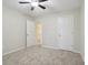 Bedroom with light-colored carpet and walls, featuring a ceiling fan and an open doorway at 11117 Harriston Dr, Fishers, IN 46037