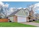 A view of the green and brick exterior, attached garage, and well-maintained lawn of this two-story home at 11117 Harriston Dr, Fishers, IN 46037
