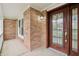 Inviting covered front porch with brick detail, outdoor sconce lighting, and a beautiful stained glass front door at 11117 Harriston Dr, Fishers, IN 46037