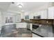 Bright kitchen with white cabinets, stainless appliances, access to the patio and unique tile flooring at 11117 Harriston Dr, Fishers, IN 46037