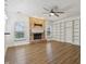 Open-concept living room with a brick fireplace, built-in shelving, a ceiling fan, and beautiful flooring at 11117 Harriston Dr, Fishers, IN 46037