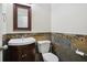 Cozy powder room with a wooden vanity, mirror and tiled accents at 11117 Harriston Dr, Fishers, IN 46037