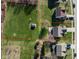 Expansive aerial view of a large, grassy lot, with a shed, surrounded by mature trees and neighboring homes at 11124 Deer Valley Dr, Indianapolis, IN 46229