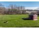 Expansive back yard featuring a fire pit, storage shed, and lush green grass at 11124 Deer Valley Dr, Indianapolis, IN 46229