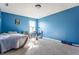 Comfortable bedroom featuring bright blue walls, a soft carpet, and a window for natural light at 11124 Deer Valley Dr, Indianapolis, IN 46229