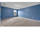 This bedroom features blue walls, a window, plush carpet, and ample space at 11124 Deer Valley Dr, Indianapolis, IN 46229
