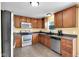 Well-lit kitchen with stainless steel appliances, wood cabinetry and tile flooring at 11124 Deer Valley Dr, Indianapolis, IN 46229