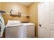 Functional laundry room with modern white washer and dryer set and shelving space at 11124 Deer Valley Dr, Indianapolis, IN 46229