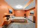 This staged primary bedroom offers an orange accent wall and a king bed with matching nightstands at 11124 Deer Valley Dr, Indianapolis, IN 46229