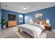 This staged primary bedroom offers blue walls, rug, and king bed with matching nightstands at 11124 Deer Valley Dr, Indianapolis, IN 46229