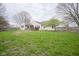 Expansive backyard with lush green grass, a hot tub, and mature trees, perfect for outdoor living at 1163 Randall Way, Brownsburg, IN 46112