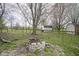 Private backyard features a stone firepit, mature trees, and storage sheds at 1163 Randall Way, Brownsburg, IN 46112