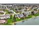 A scenic aerial view showcases upscale homes bordering a tranquil lake with large lots and lush green lawns at 12535 Glendurgan Dr, Carmel, IN 46032