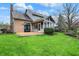 Spacious backyard with sunroom, deck, and manicured lawn at 12535 Glendurgan Dr, Carmel, IN 46032