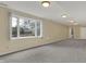 Unfinished basement featuring a large window, neutral paint and gray carpet at 12535 Glendurgan Dr, Carmel, IN 46032