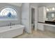 Bright bathroom features a soaking tub, stained glass window, and custom cabinetry at 12535 Glendurgan Dr, Carmel, IN 46032
